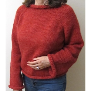 Puede incluir: Un su&eacute;ter de punto color &oacute;xido con cuello redondo y mangas largas. El su&eacute;ter tiene un dobladillo y pu&ntilde;os acanalados. Las mangas son ligeramente acampanadas. El su&eacute;ter est&aacute; hecho de un hilo suave y texturizado.