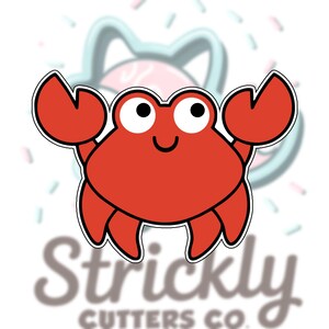 May include: A red cartoon crab with large black eyes and a smiling mouth. The crab has two large claws and is outlined in black. The background includes a blurred image of a cat-shaped cookie cutter and the text "Strickly CUTTERS CO."