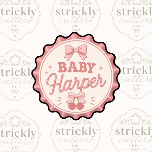 May include: A pink and white circular design with the text "BABY Harper" in a script font. The design includes bows, cherries, and star accents, with a scalloped edge. The background features a repeating pattern of a logo.