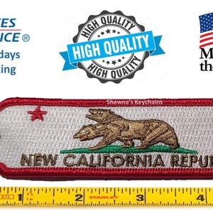 May include: A red, white and green embroidered keychain featuring a three-headed bear and the text "NEW CALIFORNIA REPUBLIC".
