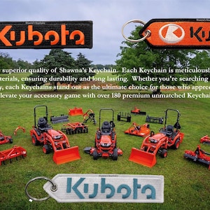Può includere: Tre portachiavi di trattore Kubota rosso e nero con un portachiavi Kubota nero e arancione e un portachiavi Kubota bianco e turchese. I portachiavi sono esposti su un prato verde con diversi trattori Kubota rossi in miniatura.
