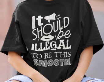 Könnte beinhalten: Schwarzes T-Shirt mit dem weißen Text "It SHOULD be ILLEGAL to be THIS SMOOTH." Das Design beinhaltet ein Megaphon und Lippen. Das Shirt hat eine lässige, übergroße Passform.