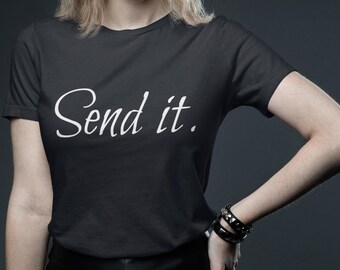 May include: Black t-shirt with the white text "Send it." The shirt has short sleeves and a crew neck. The model is wearing black bracelets.