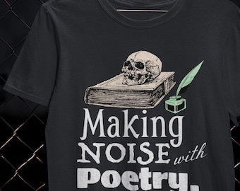 May include: Black t-shirt with a graphic design featuring a skull on a book, a quill, and inkwell. The text reads "Making NOISE with Poetry." The design is in white and green. The shirt is a crew neck.
