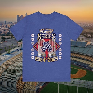 Peut inclure: T-shirt bleu avec un graphisme sur le thème du baseball. Le motif comprend le texte "Back to Back World Series" au-dessus d'un logo et les années 2024 et 2025. D'autres années sont répertoriées.
