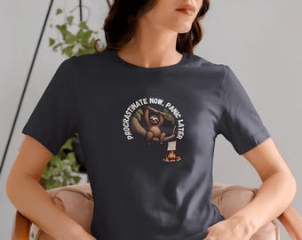 Könnte beinhalten: Ein dunkelgraues T-Shirt mit einer weißen Grafik eines Faultiers, das an einem Ast hängt, mit dem Text "Procrastinate Now, Panic Later".