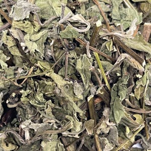 May include: Close-up of dried, green, and tan leaves and stems. The leaves have a textured appearance with curled edges. The image is a top-down view, showcasing the natural, organic texture of the dried plant material.