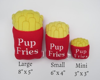 May include: Three plush dog toys shaped like french fries in a red container. The toys are labeled "Pup Fries" and come in three sizes: large (8 inches by 5 inches), small (6 inches by 4 inches), and mini (3 inches by 3 inches).