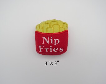May include: Red and yellow felt toy shaped like a box of french fries. The box says "Nip Fries" and measures 3 inches by 3 inches.