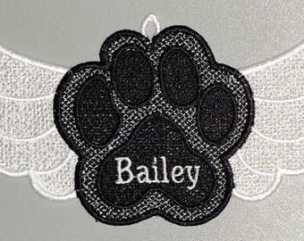 May include: Embroidered patch featuring a black paw print with the name "Bailey" in white, set against a pair of white wings. The patch is designed with a detailed, textured appearance, suitable for pet memorial items.