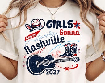 Könnte beinhalten: Ein cremefarbenes T-Shirt mit einem Grafikdruck, der einen Cowboyhut, eine Gitarre und Cowboystiefel zeigt. Der Text lautet Girls Gonna Nashville, Tennessee und 2027. Das Design enthält rote, weiße und blaue Sterne sowie Musiknoten.