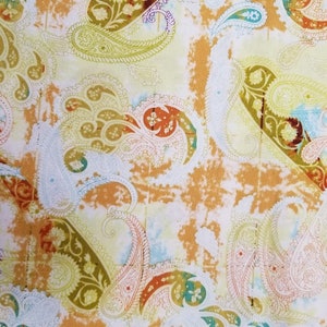 May include: A fabric with a paisley pattern in shades of orange, green, and blue on a white background.