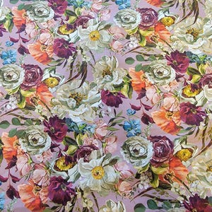 May include: A floral pattern featuring a variety of flowers in shades of white, purple, orange, and blue. The flowers are arranged on a light purple background. The design includes roses, peonies, and other blossoms, creating a vibrant and detailed textile pattern.