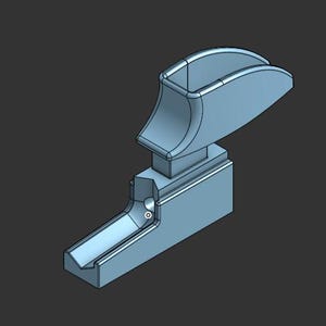 K&ouml;nnte beinhalten: Eine hellblaue, 3D-gerenderte mechanische Komponente mit einer rechteckigen Basis, die eine V-f&ouml;rmige Rinne aufweist, sowie einem vertikalen Aufsatz, der von einer geschwungenen, hohlen griffartigen Struktur gekr&ouml;nt wird, mit glatten Oberfl&auml;chen.
