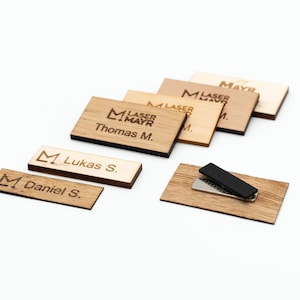 Può includere: Etichette per nomi in legno con retro magnetico nero. Le etichette presentano un logo con il testo "Laser Mayr" e i nomi "Lukas S.", "Daniel S." e "Thomas M.".