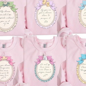 a collection of pink t-shirts with various phrases and illustrations on them.