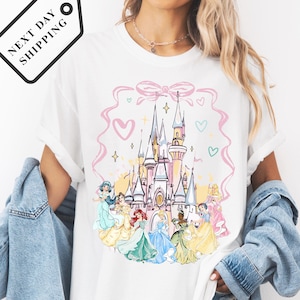 A woman wearing a white t-shirt with a Disney princess castle graphic printed on it.
