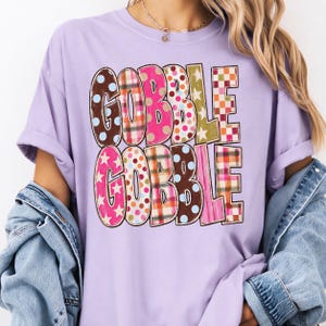 A person wearing a purple t-shirt with the text "GOBBLE GOBBLE" printed on it.