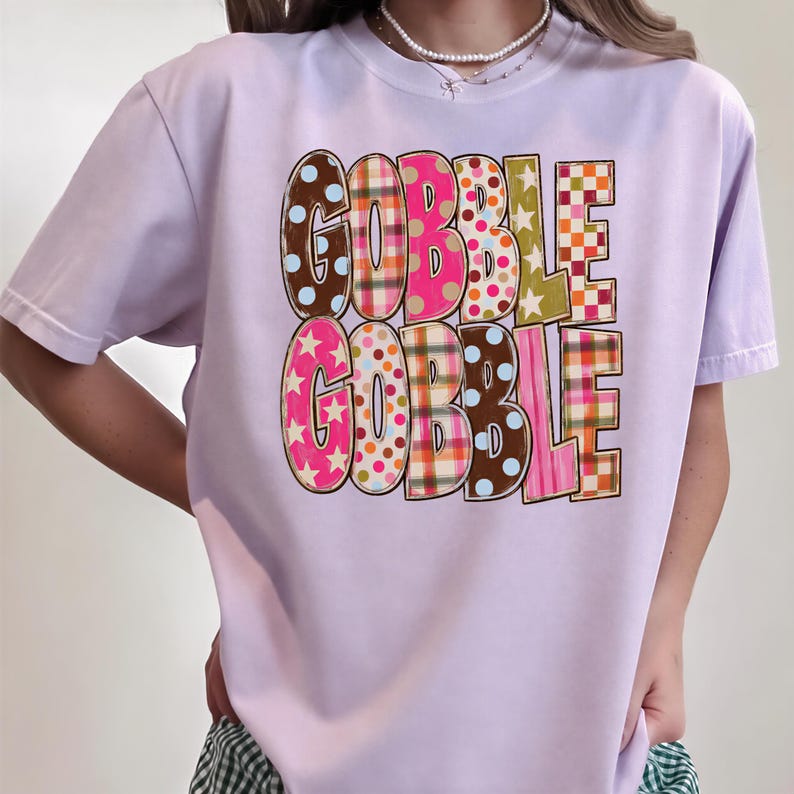 A person wearing a pink t-shirt with the text "GOBBLE GOBBLE" printed on it.