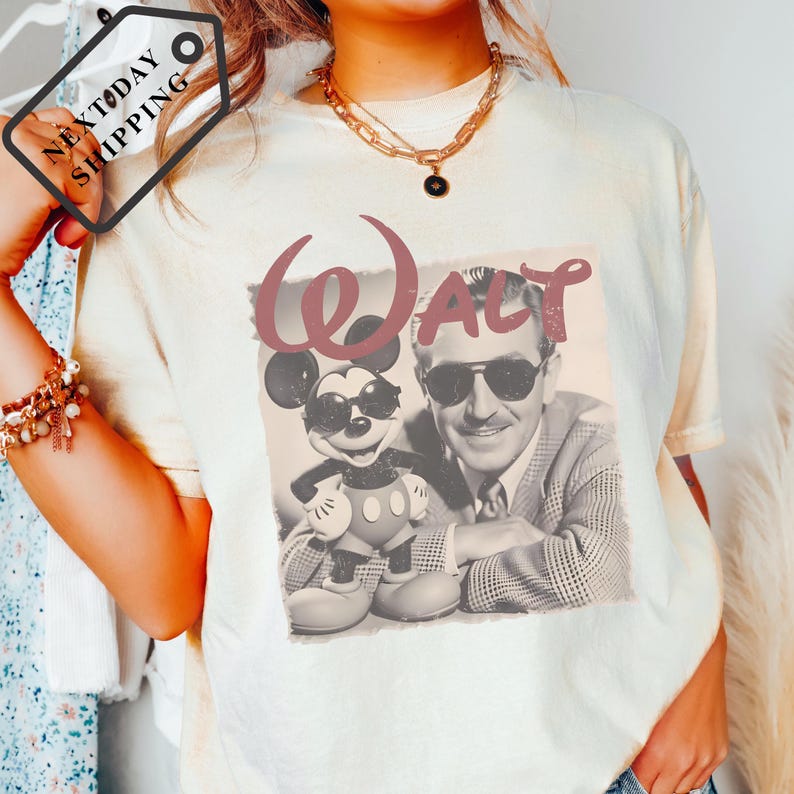 A person wearing a white t-shirt with a graphic of Walt Disney and Mickey Mouse.