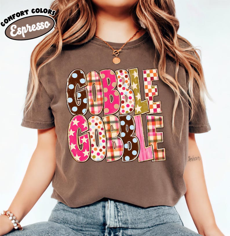 A woman wearing a brown t-shirt with the text "GOBBLE GOBBLE" printed on it.