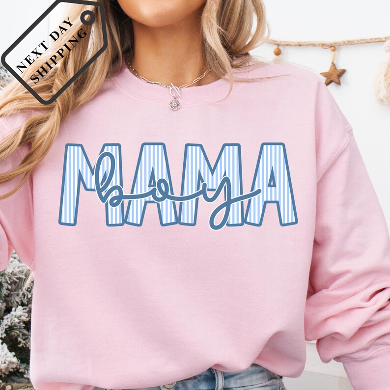 A woman wearing a pink sweatshirt with the word "MAMA" printed on it.