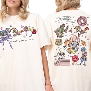 two white t-shirts with colorful cartoon characters and various designs on the back.