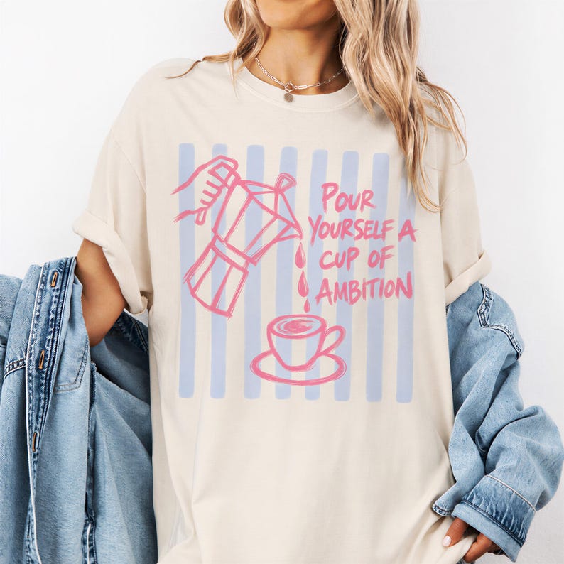 A woman wearing a white t-shirt with a graphic design and text printed on it.