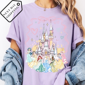 A person wearing a purple t-shirt with a Disney princess castle graphic printed on it.