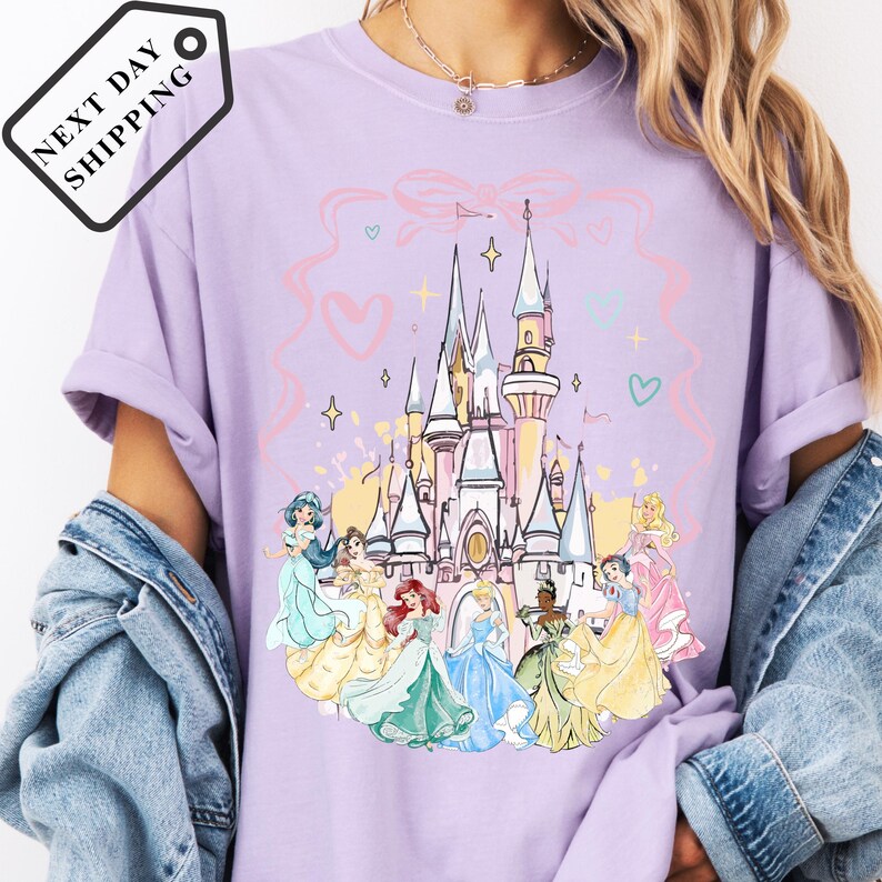 A person wearing a purple t-shirt with a Disney princess castle graphic printed on it.