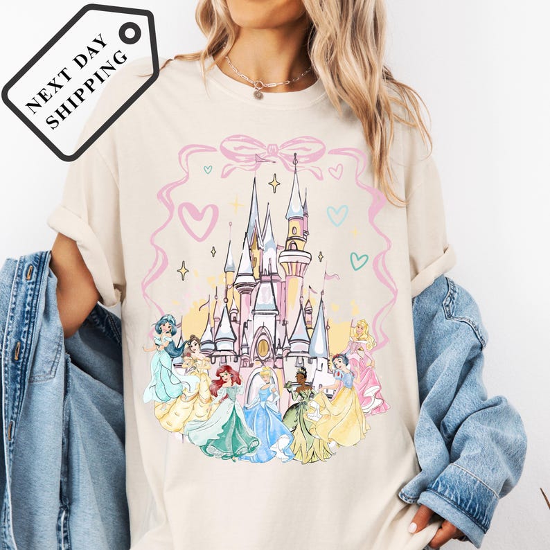 A woman wearing a white t-shirt with a Disney princess castle graphic printed on it.