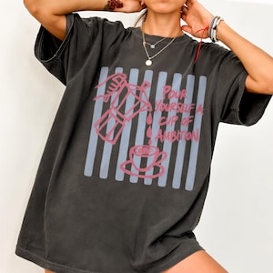 A person wearing a black t-shirt with a graphic design printed on it.