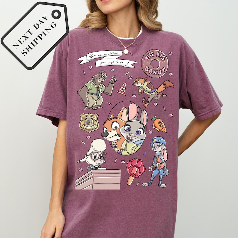 A person wearing a purple t-shirt with various cartoon characters and designs, including a character resembling a fox, a character resembling a rabbit, and a character resembling a police officer.