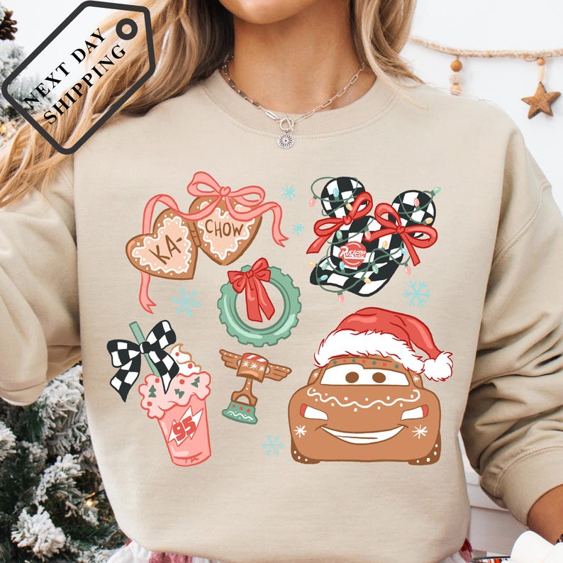 A person wearing a beige sweater with various Christmas-themed illustrations, including a Santa hat, gingerbread houses, and other festive decorations.