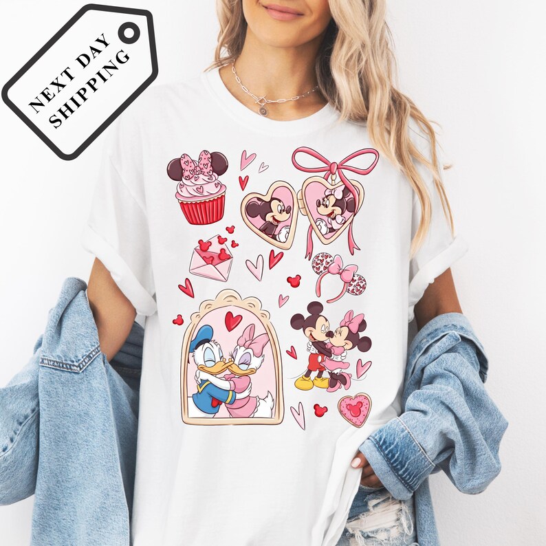 A woman wearing a white t-shirt with a graphic design featuring Minnie Mouse and other Disney characters.