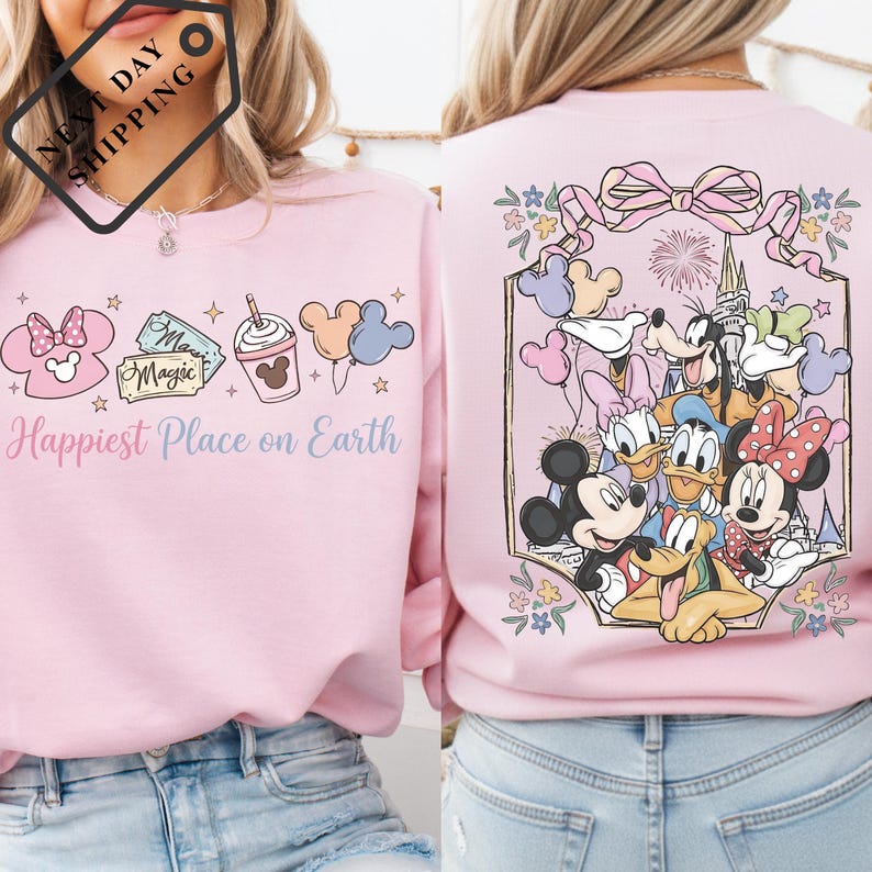 a woman wearing a pink sweater with a Disney-themed design on the back.