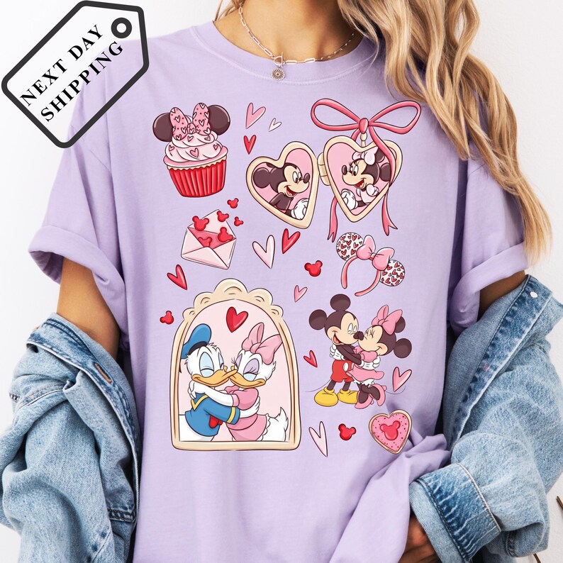 A person wearing a purple t-shirt with various Disney characters and heart-shaped designs printed on it.