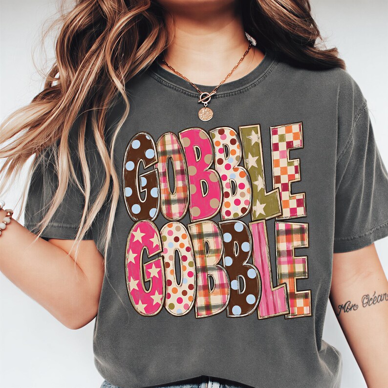 A person wearing a gray t-shirt with the text "GOBBLE GOBBLE" printed on it.