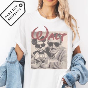A woman wearing a white t-shirt with a graphic of Mickey Mouse and a man, along with the text "Walt".