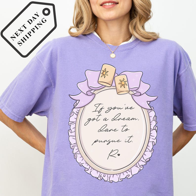 A woman wearing a purple t-shirt with a quote printed on it.