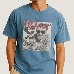 A man wearing a blue t-shirt with a graphic design featuring a man and a character from Disney.