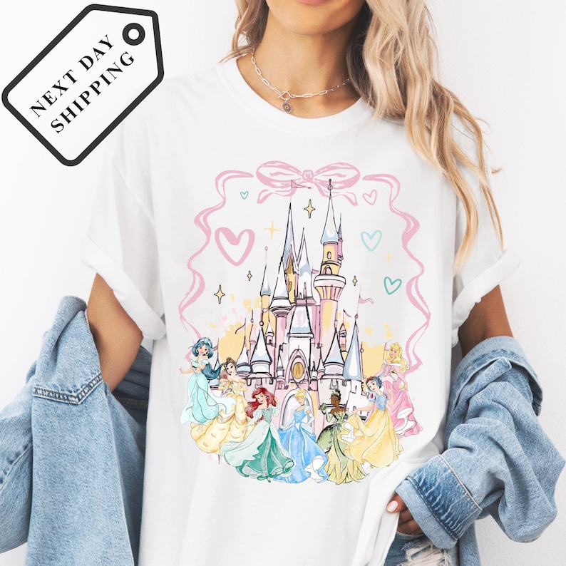 A woman wearing a white t-shirt with a Disney princess castle graphic printed on it.