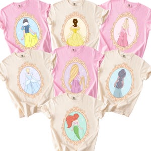 a collection of t-shirts featuring illustrations of various Disney princesses, including Snow White, Belle, Ariel, and mermaids.