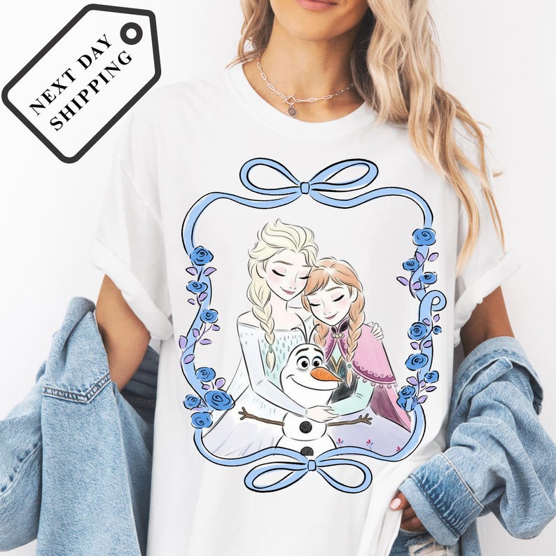A woman wearing a white t-shirt with a graphic design featuring two girls and a snowman.