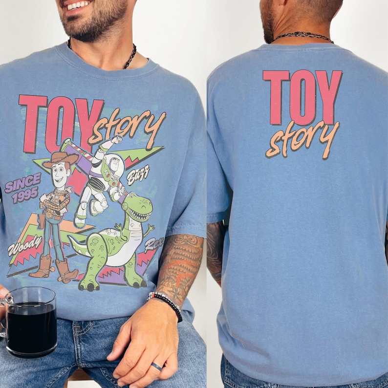 A man wearing a blue t-shirt with a colorful graphic of Woody and Buzz Lightyear from the Toy Story movie.