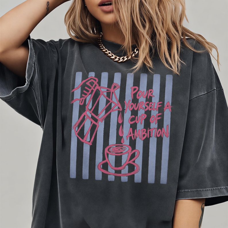 A woman wearing a black t-shirt with a graphic design on it.