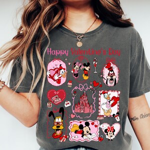 A woman wearing a gray t-shirt with various Disney characters and illustrations, including Minnie Mouse, Mickey Mouse, Donald Duck, and other popular Disney characters.