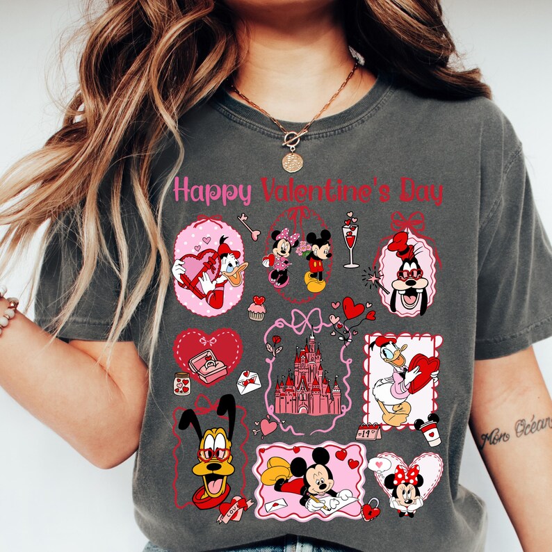 A woman wearing a gray t-shirt with various Disney characters and illustrations, including Minnie Mouse, Mickey Mouse, Donald Duck, and other popular Disney characters.