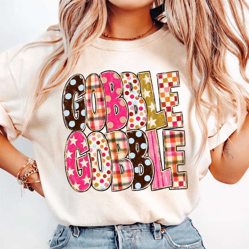 A woman wearing a white t-shirt with the text "GOBBLE GOBBLE" printed on it.