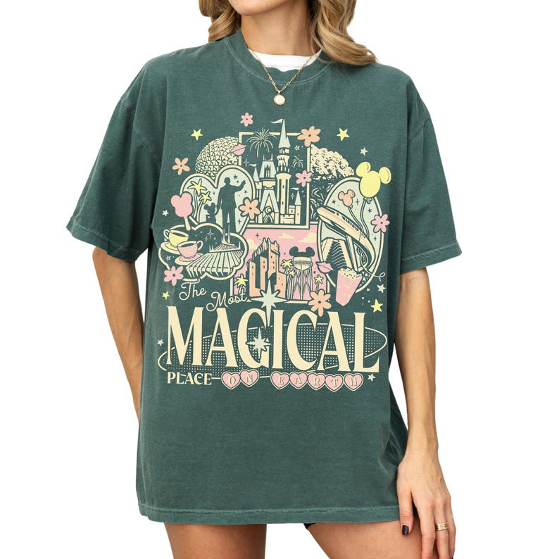 A green t-shirt with a graphic design featuring various Disney-themed elements, including a castle, Mickey Mouse, and other iconic imagery.